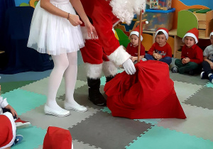Mikołaj obdarowuje prezentami